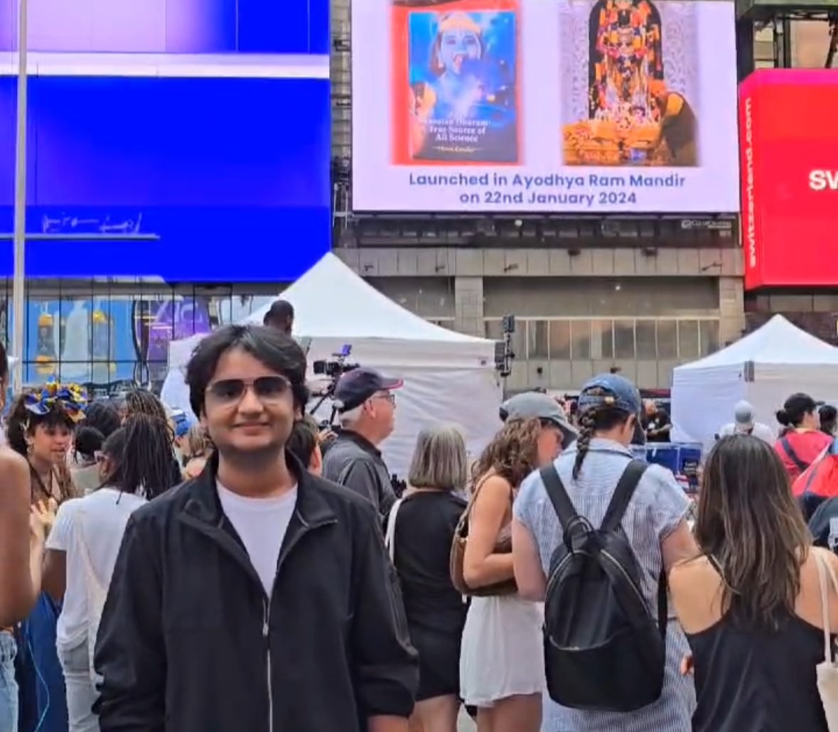 Vivaan Karulkar in Times Square, New York, with his book on the billboard behind him