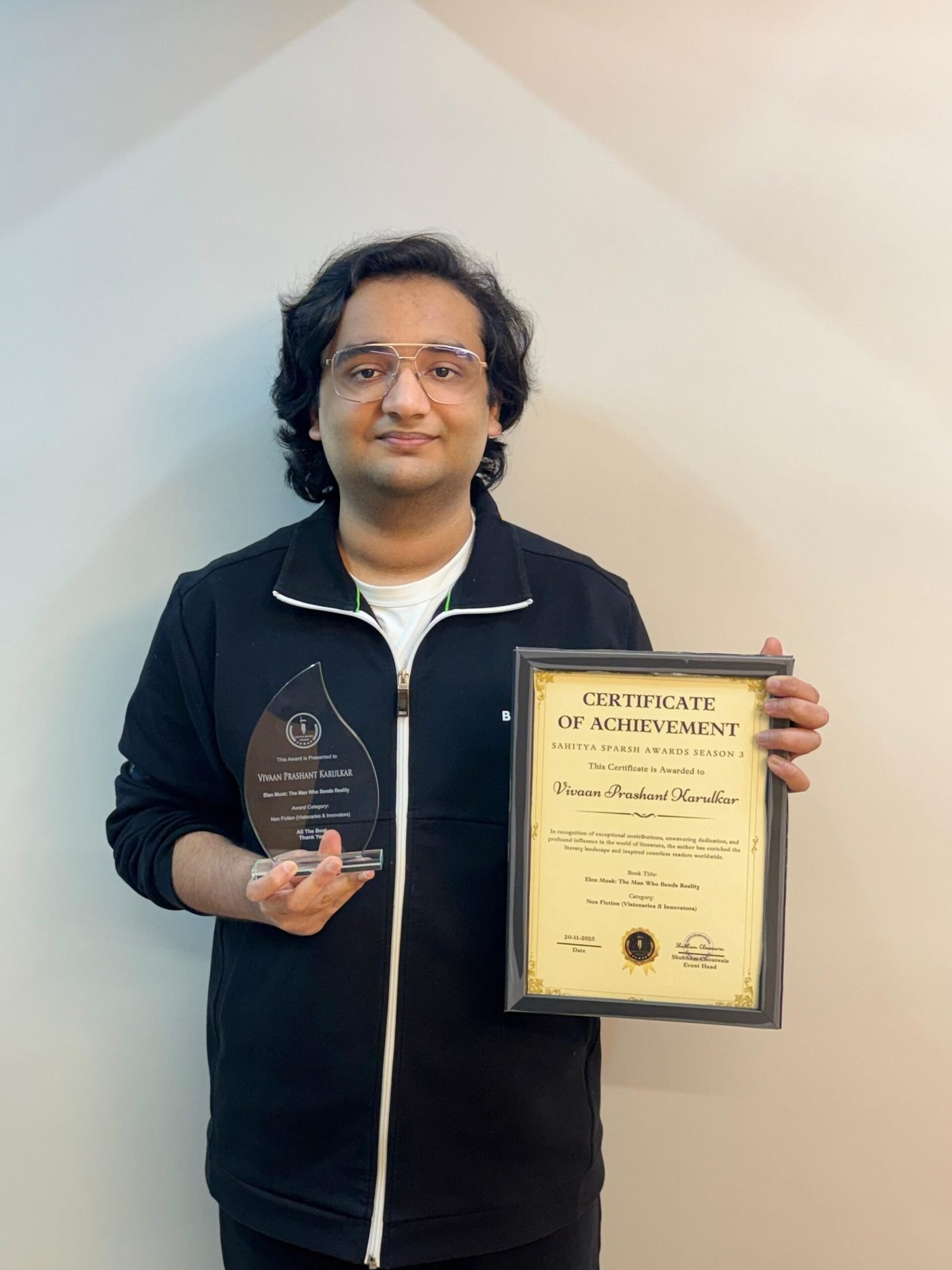 Portrait of Vivaan Karulkar holding the Sahitya Sparsh Award trophy and certificate
